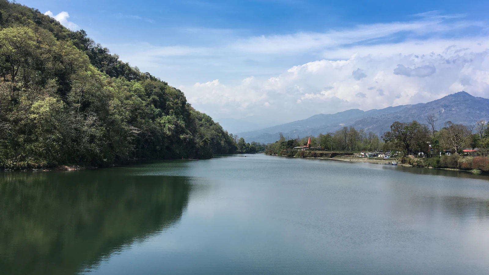 Phewa Lake beside forested slopes and the Lakeside shore.